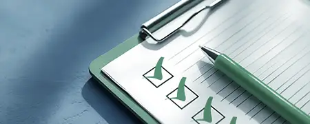 Notizblock mit Häkchen und Stift für Aufgabenplanung